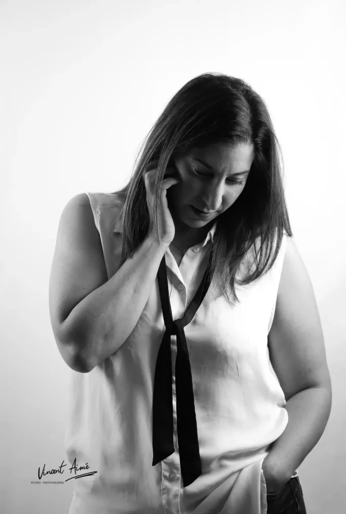 Femme se tenant debout, baissant la tête. Photo en noir et blanc