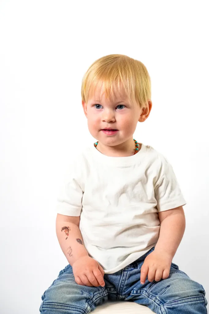 Enfant souriant, assis sur un tabouret