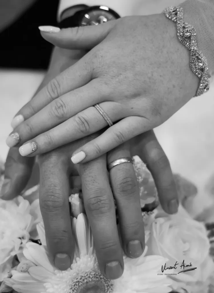 Mains des mariés avec mise en avant des alliances. Photo en noir et blanc