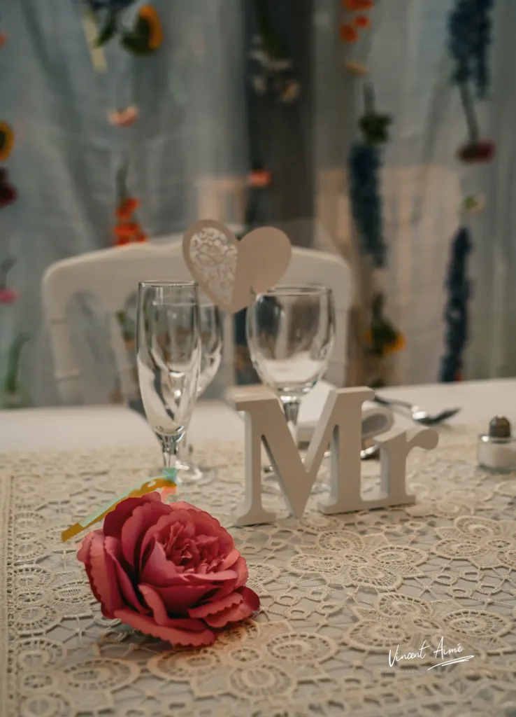 Table du marié avec une fleur rose et les lettres Mr en blanc