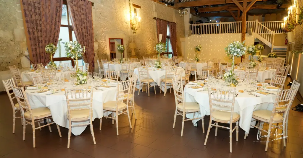 Salle de réception de mariage avec tables dressées et fleuries