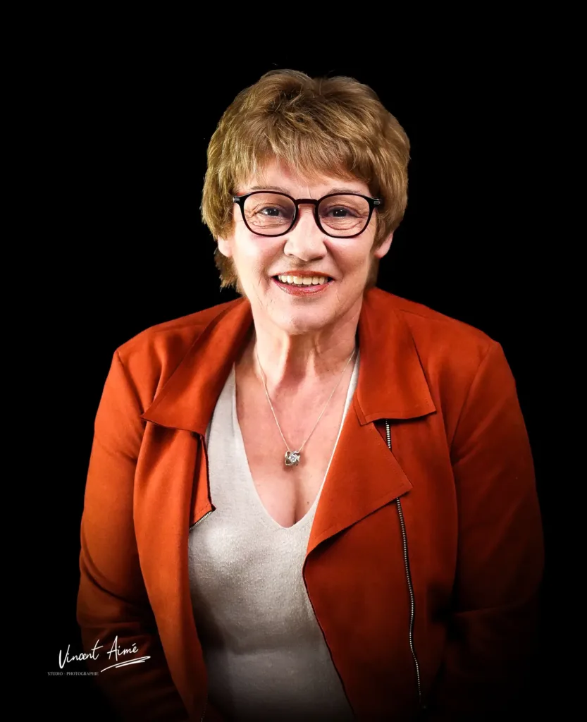 Portrait d'une femme de face, avec une veste en cuir rouge. Fond noir en arrière-plan