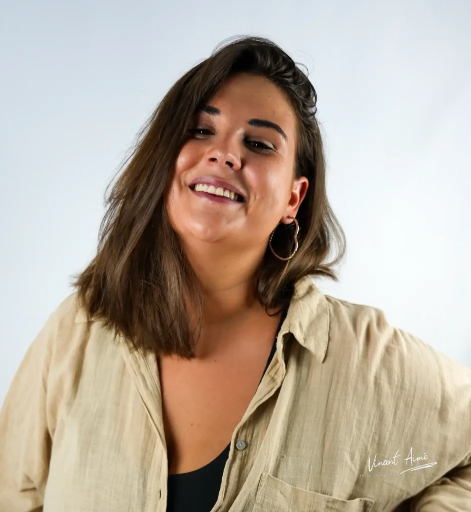 Portrait d'une femme de face, souriant. Fond blanc en arrière-plan
