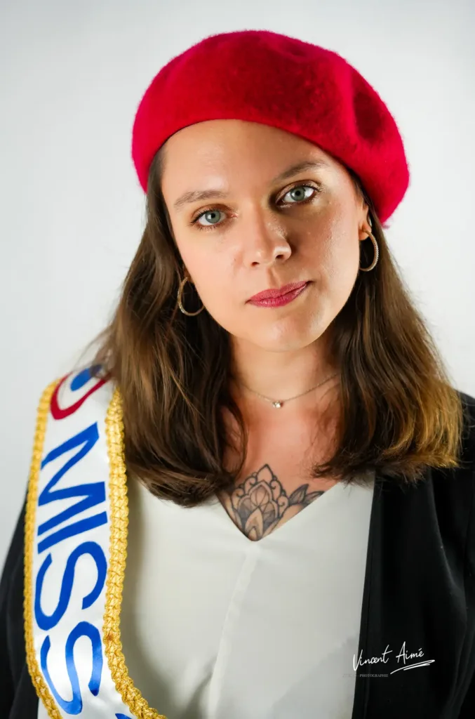 Portrait d'une femme portant une béret rouge et une écharpe de Miss.