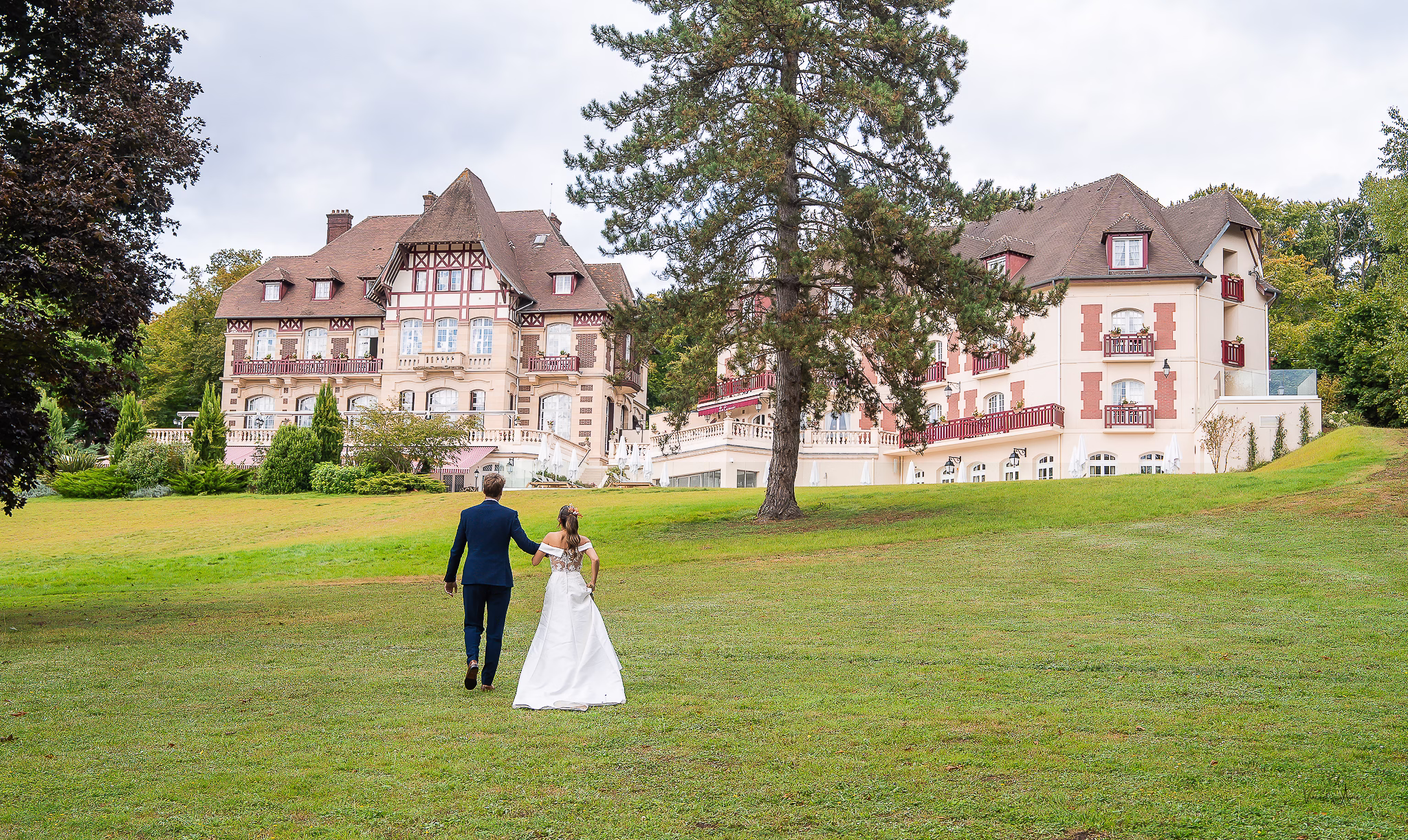 Nouveaux mariés de dos allant vers le chateau